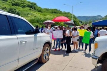 Detienen manifestantes la camioneta de AMLO en Durango.