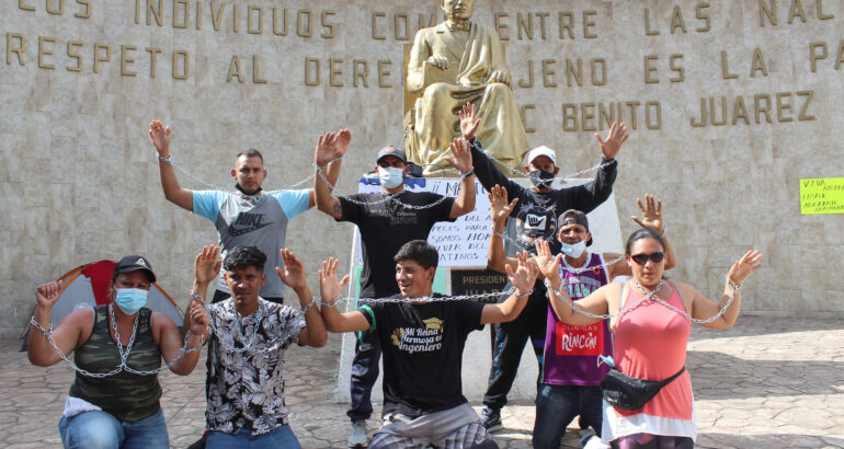 Migrantes centroamericanos se encadenan para protestar y pedir la entrega de documentos de tránsito en Tapachula, estado de Chiapas (México). Foto de EFE/ Juan Manuel Blanco