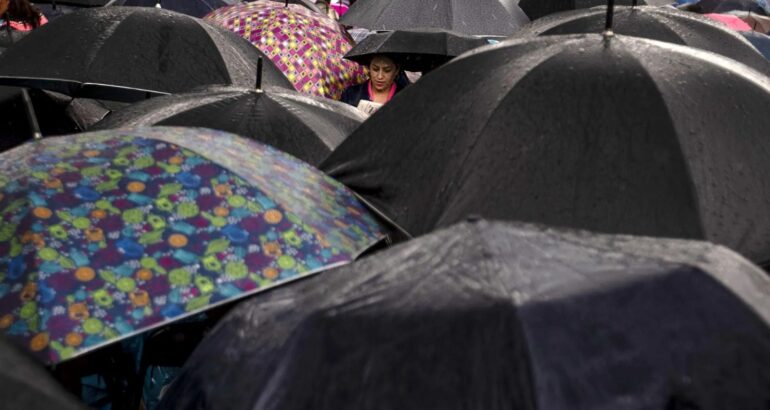 Personas cubriéndose de la lluvia con paraguas. Foto de Notimex / Archivo