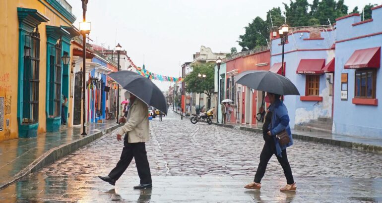 Personas se protegen de la lluvia en Oaxaca, en una imagen de archivo. Foto de EFE/Daniel Ricardez