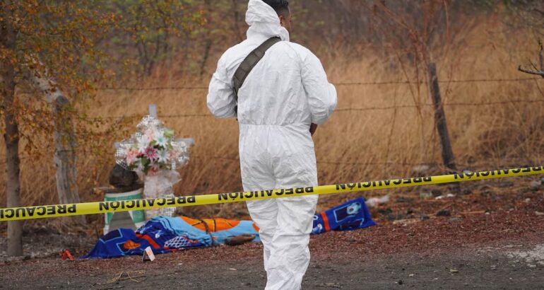 Un perito forense frente al cuerpo de una víctima de asesinato, en la carretera Apatzingán – Buenavista, en una imagen de archivo. Juan José Estrada Serafín (CUARTOSCURO).