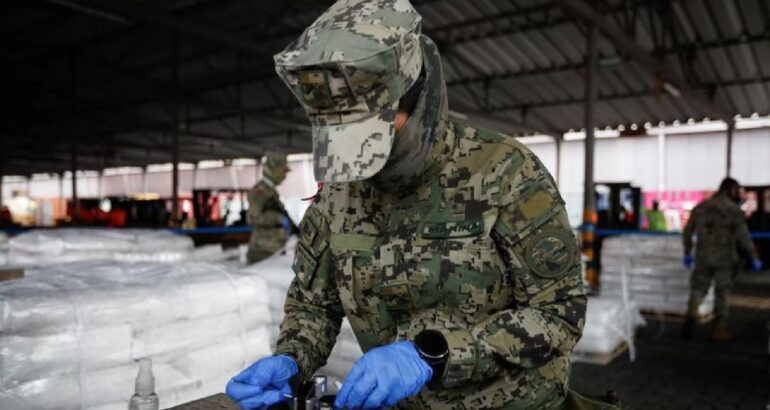 Un miembro de la Armada de México prueba un cargamento de sustancias químicas de doble uso en el Puerto de Manzanillo como medida para prevenir el contrabando de sustancias prohibidas, en Manzanillo, Colima, México, 14 de diciembre de 2023. (REUTERS/Daniel Becerril).