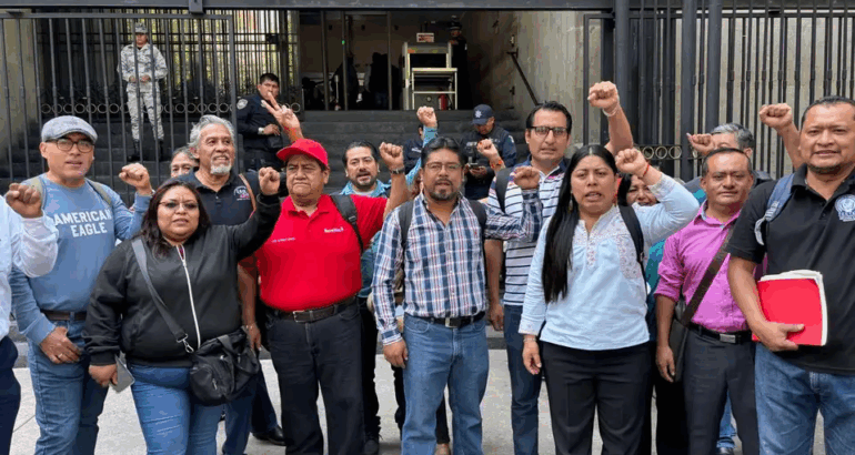 Dirigentes magisteriales del CNTE levantan el puño previo a ingresar a Gobernación para dialogar con el gobierno federal. Imagen Laura Poy.