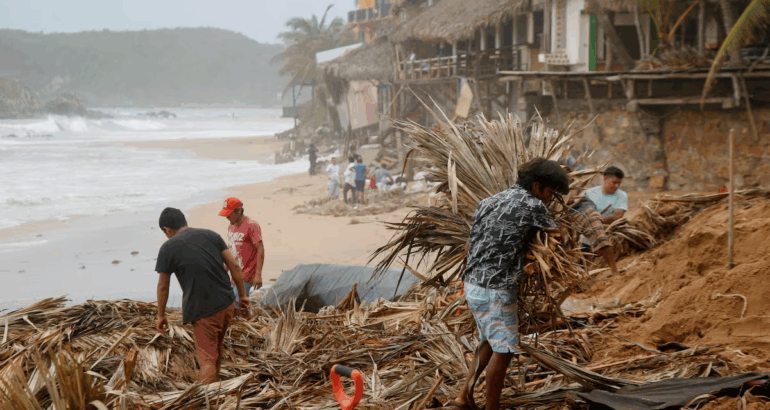 Pobladores de San Agustinillo, Oaxaca, comienzan labores de limpieza a lo largo de la costa, tras el paso del huracán, el 19 de junio. Jorge Luis Plata (REUTERS)