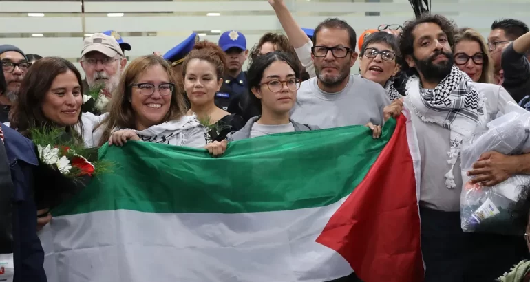 De izquierda a derecha los activistas mexicanos: Laura Alejandra Vélez, Sol González, Arlín Medrano, Ernesto Ledesma y Diego Vázquez posan con la bandera de Palestina a su llegada al Aeropuerto Internacional de la Ciudad de México. (Foto de Mario Guzmán de la agencia EFE)